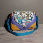 jude marylou face un sac besace multicolore et printanier un motif rétro et des couleurs pop